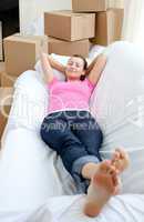 Charming woman relaxing on a sofa with boxes