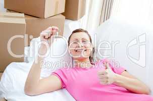 Positive woman relaxing on a sofa with boxes