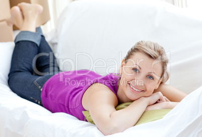 Portrait of a positive woman relaxing on a sofa with boxes