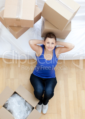 Relaxed woman sitting between boxes at home