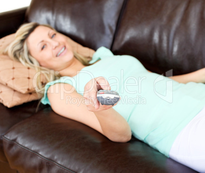 Delighted woman using a remote