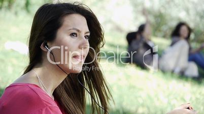Girl sitting listening outdoor grass
