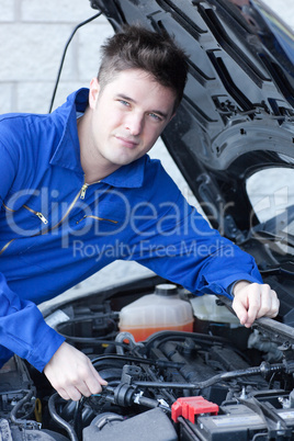 Smiling man repairing a car