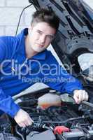 Smiling man repairing a car