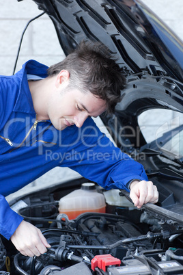 Concentrated man repairing a car