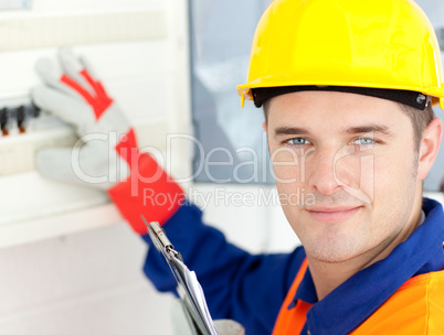 Smiling electrician repairing a power plan