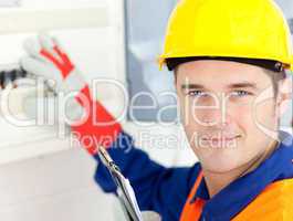 Smiling electrician repairing a power plan