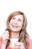 Cheerful woman eating a yogurt