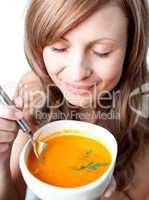 Delighted woman holding a soup bowl