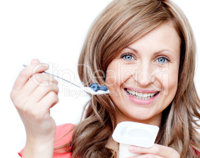 Smiling woman eating a yogurt