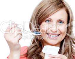 Smiling woman eating a yogurt