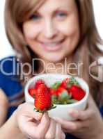 Cute woman eating strawberries