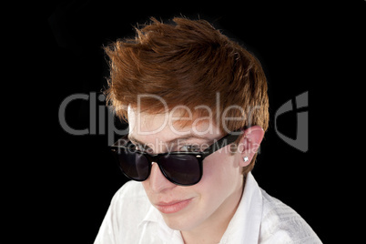 Young man with sunglasses posing on a black background