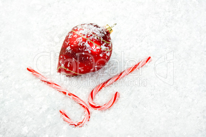 Candy Canes and Ornament lying in the snow