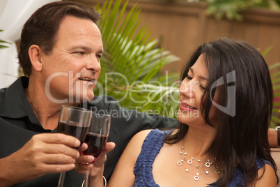 Attractive Hispanic and Caucasian Couple Drinking Wine