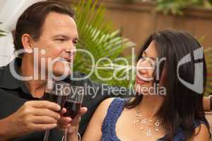 Attractive Hispanic and Caucasian Couple Drinking Wine