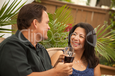 Attractive Hispanic and Caucasian Couple Drinking Wine