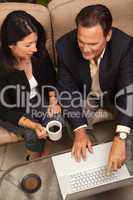 Man and Woman Using Laptop with Coffee