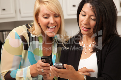 Two Girlfriends Sharing with Their Cell Phones