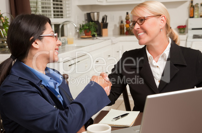 Businesswomen Shaking Hands Working on the Laptop