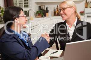 Businesswomen Shaking Hands Working on the Laptop