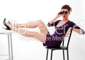 Youth woman sitting on chair and looking on binoculars.