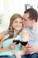 Portrait of an affectionate young couple drinking red wine