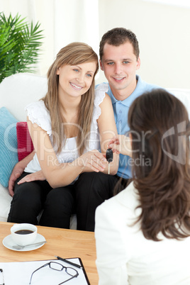 Happy young couple receiving their new car's key