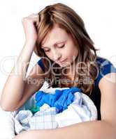Unhappy woman doing laundry