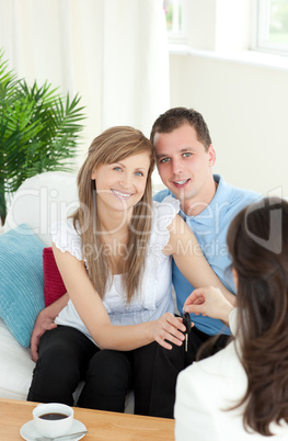 Jolly young couple receiving their new car's key