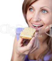 Radiant woman eating a cracker with cheese