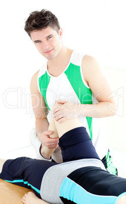 Young male physical therapist checking a woman's knee