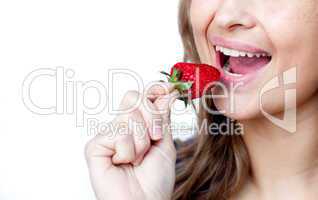 Close-up of a young woman eating a strawberry