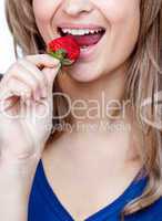 Close-up of a woman eating a strawberry