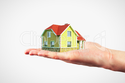 man holding model house in a hand