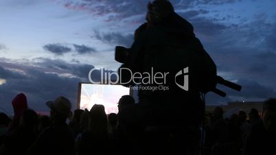 A camera man on a dolly at a music festival