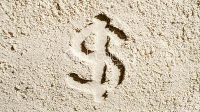 A dollar symbol erodes in the sand
