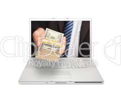 Businessman Handing Stack of Money Through Laptop Screen