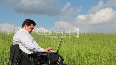 Businessman sitting outdoors using laptop