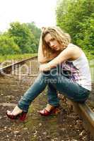 girl in jeans sits on rail