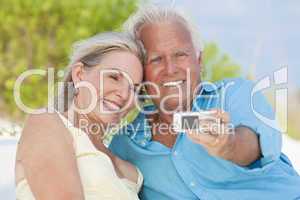 Happy Senior Couple Taking Photographs On Cell Phone At Beach