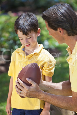 Father Teaching His Son To Play American Football