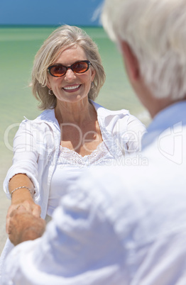 Happy Senior Couple Dancing Holding Hands on A Tropical Beach