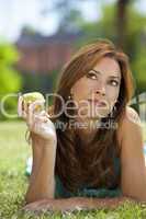 Beautiful Woman Outside Eating An Apple and Thinking