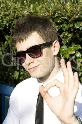 Teenager on park bench sign OK