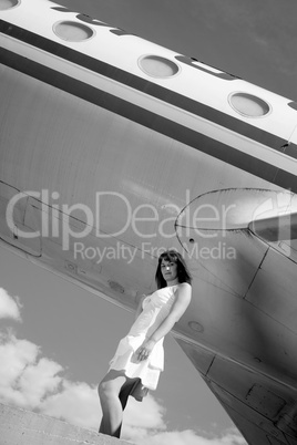 Girl posing with an airplane behind