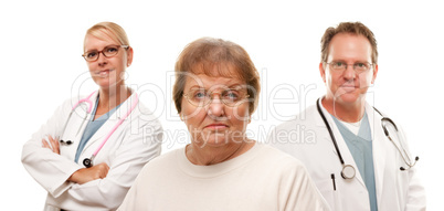 Concerned Senior Woman with Doctors Behind.