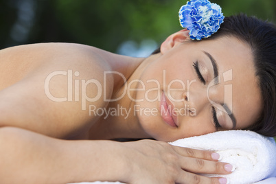 Beautiful Brunette Woman Relaxing At Health Spa WIth Blue Flower
