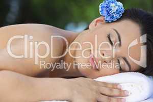 Beautiful Brunette Woman Relaxing At Health Spa WIth Blue Flower