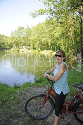 Radfahrerin an einem Waldsee